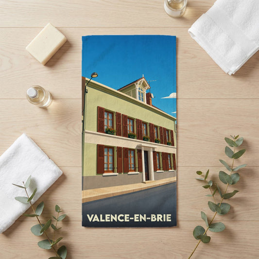 Serviette de bain souvenir de la ville de Valence-en-Brie avec une illustration stylisée d'un bâtiment traditionnel.