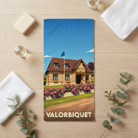 Serviette de bain souvenir de la ville de Valorbiquet avec une illustration stylisée d'un manoir normand.