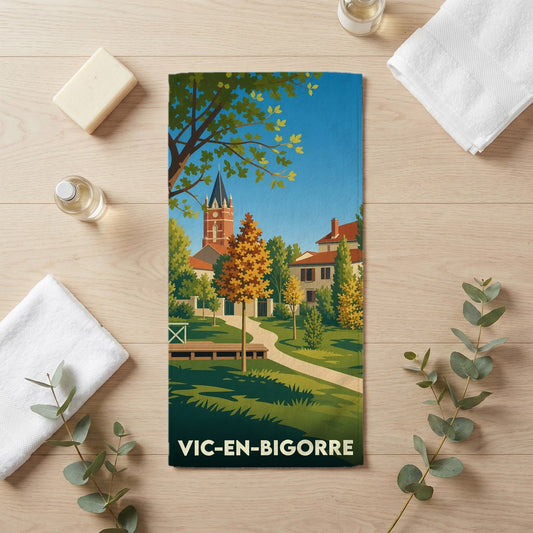 Serviette de bain souvenir de la ville de Vic-en-Bigorre avec une illustration stylisée d'un parc et de son église.