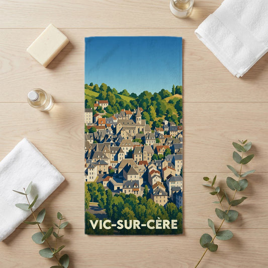 Serviette de bain souvenir de la ville de Vic-sur-Cère avec une illustration stylisée.