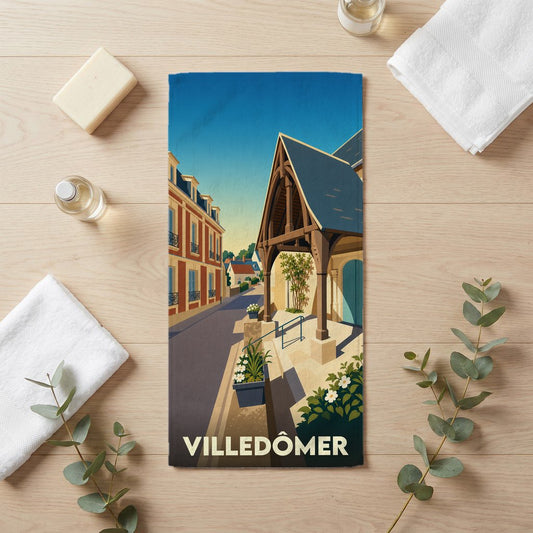 Serviette de bain souvenir de la ville de Villedômer avec une illustration de rue stylisée.