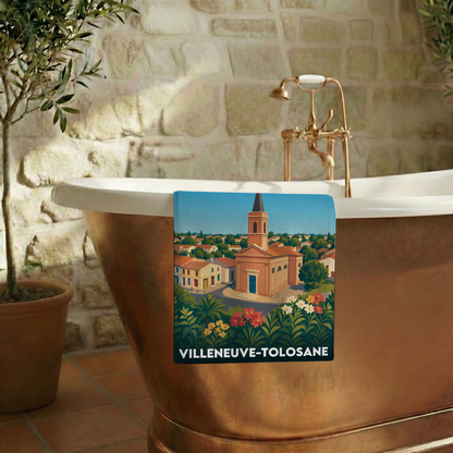 Serviette de bain souvenir de Villeneuve-Tolosane illustrée d'une vue stylisée de la ville et de son église.