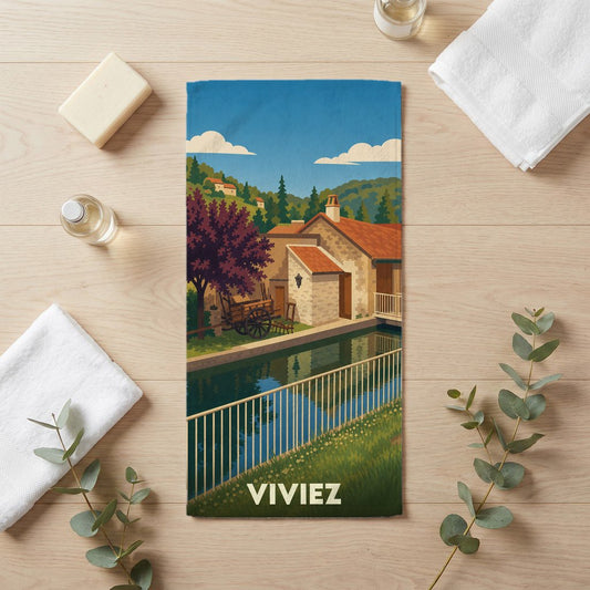 Serviette de bain souvenir de la ville de Viviez avec une illustration stylisée de paysage.