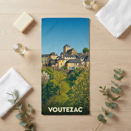 Serviette de bain souvenir de la ville de Voutezac avec une illustration stylisée de ses maisons et de sa nature verdoyante.