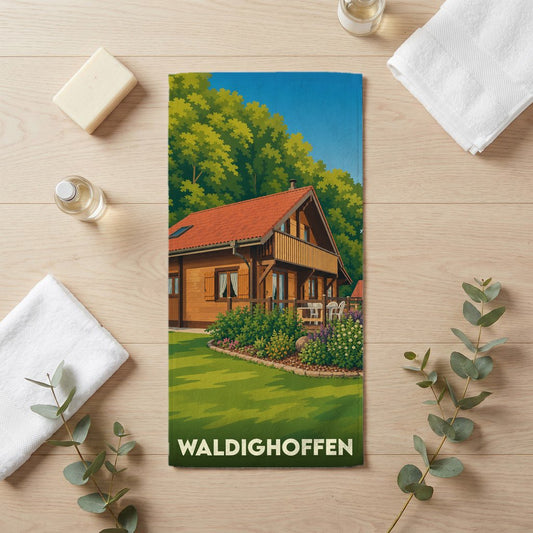 Serviette de bain souvenir de la ville de Waldighoffen avec une illustration stylisée d'un chalet en bois.
