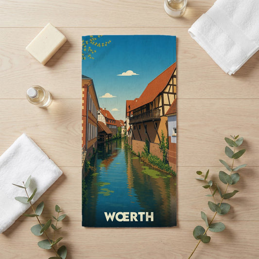 Serviette de bain souvenir de la ville de Wœrth avec une illustration stylisée d'un canal bordé de maisons à colombages.