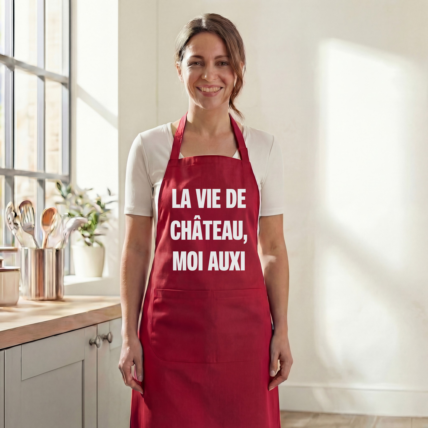 Tablier de cuisine rouge souvenir de la ville d'Auxi-le-Château avec l'inscription « LA VIE DE CHÂTEAU, MOI AUXI ».