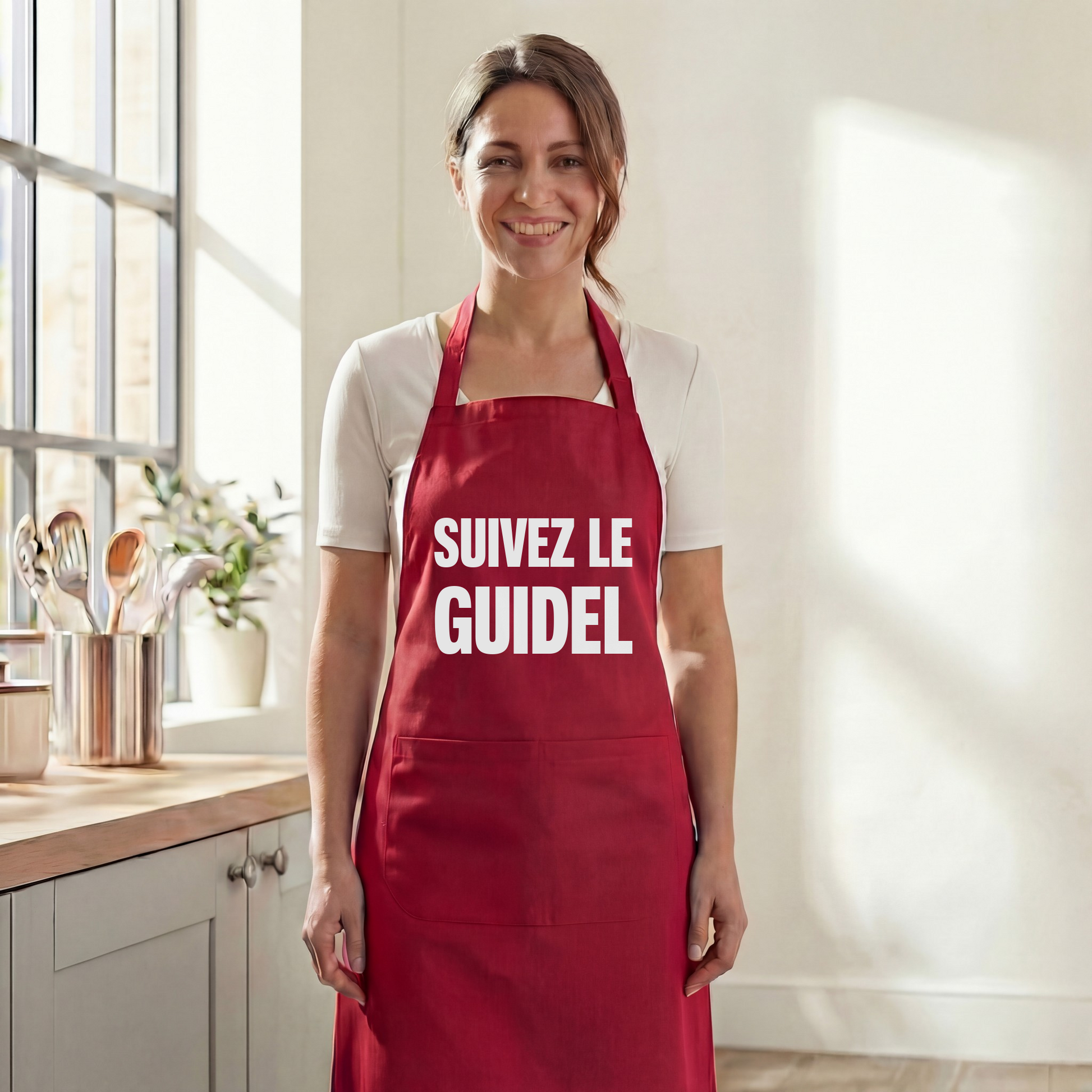 Tablier de cuisine rouge souvenir de la ville de Guidel avec l'inscription « Suivez le Guidel ».
