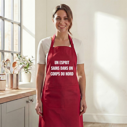 Tablier de cuisine rouge avec une inscription humoristique, souvenir de la ville de Sains-du-Nord.