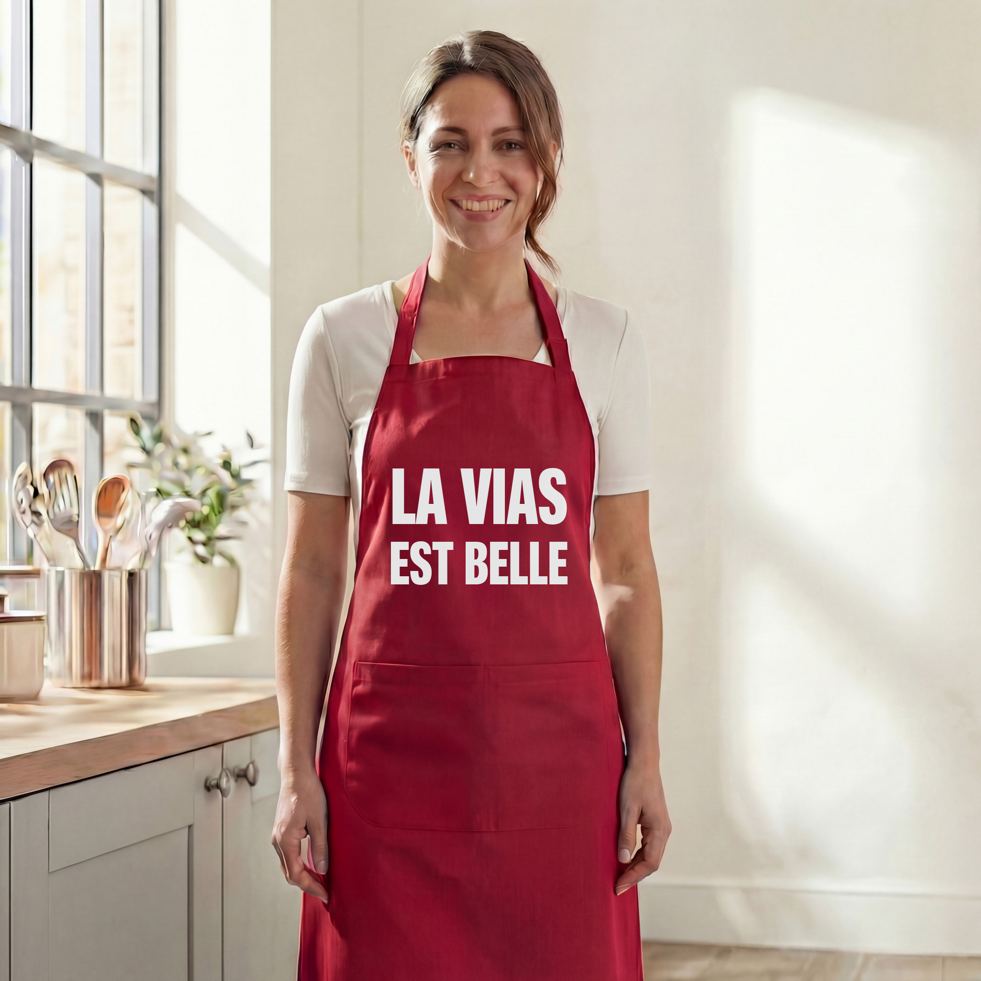 Tablier de cuisine rouge souvenir de la ville de Vias avec l'inscription "La Vias est belle".