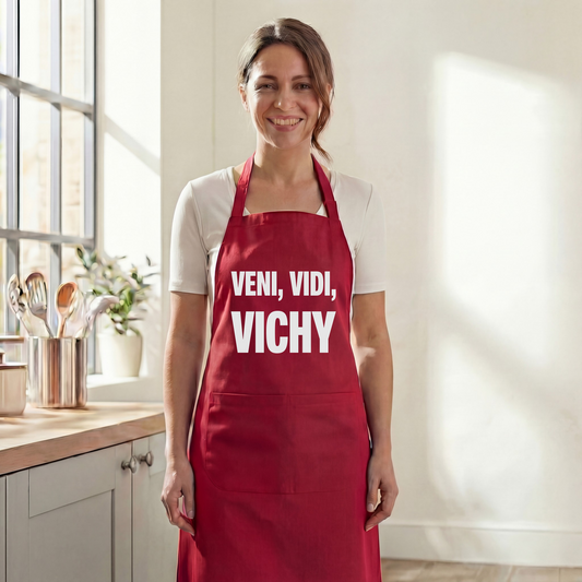 Tablier de cuisine rouge souvenir de la ville de Vichy avec l'inscription « VENI, VIDI, VICHY ».