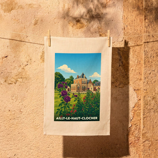 Torchon souvenir de la ville d'Ailly-le-Haut-Clocher avec une illustration stylisée d'une demeure et d'un jardin fleuri.