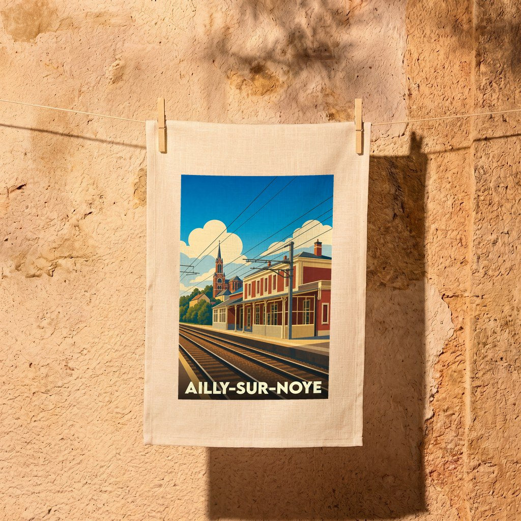 Torchon souvenir de la ville d'Ailly-sur-Noye avec une illustration stylisée de sa gare et de son église.