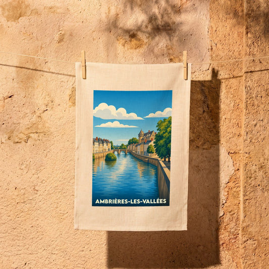 Torchon souvenir de la ville d'Ambrières-les-Vallées avec une illustration stylisée de ses quais et de sa rivière.