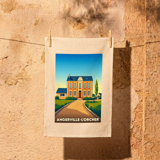 Torchon souvenir de la ville d'Angerville-l'Orcher avec une illustration stylisée d'une maison de maître normande.