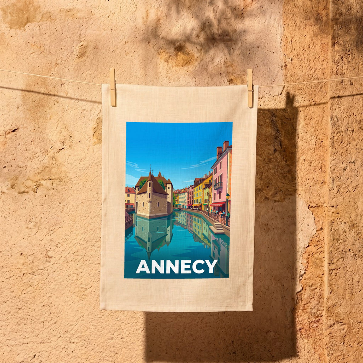 Torchon souvenir de la ville d'Annecy avec une illustration stylisée de ses célèbres canaux.