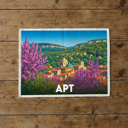 Torchon souvenir de la ville d'Apt orné d'une illustration stylisée du village provençal et de ses collines.