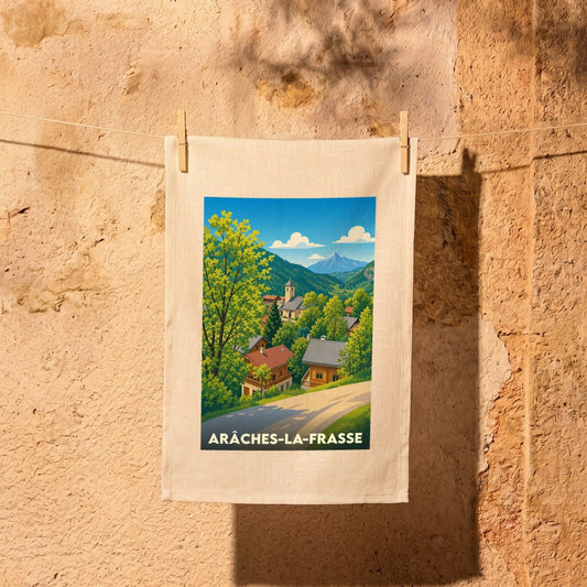 Torchon souvenir de la ville d’Arâches-la-Frasse avec une illustration stylisée d’un village de montagne.