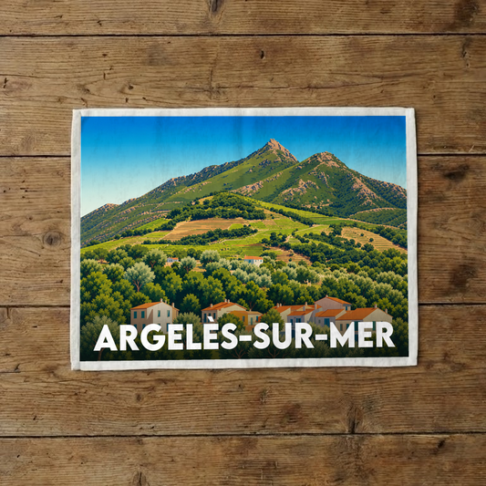 Torchon souvenir de la ville d'Argelès-sur-Mer avec une illustration stylisée d'un paysage montagneux.