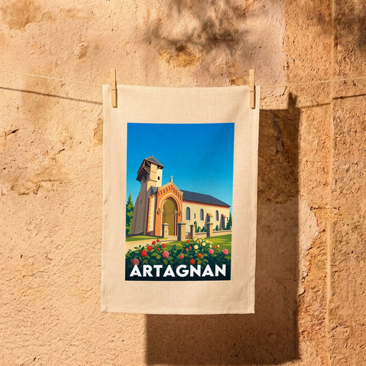Torchon souvenir de la ville d'Artagnan illustré d'une église sous un ciel bleu.