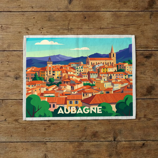 Torchon souvenir de la ville d'Aubagne avec une illustration stylisée et colorée de ses paysages provençaux.