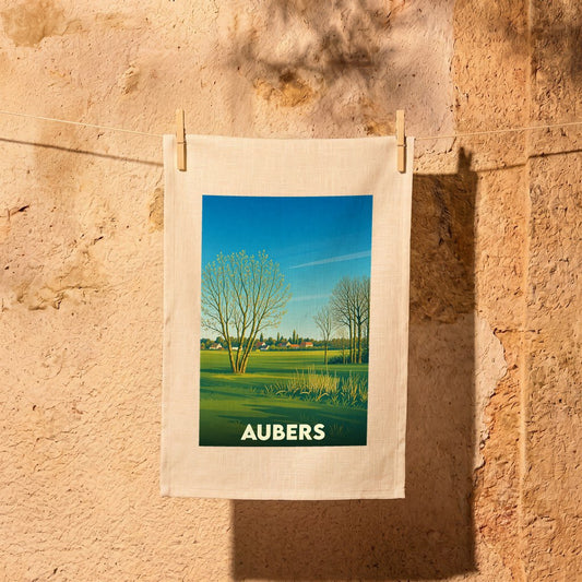 Torchon souvenir de la ville d'Aubers avec une illustration stylisée d'un paysage de campagne.