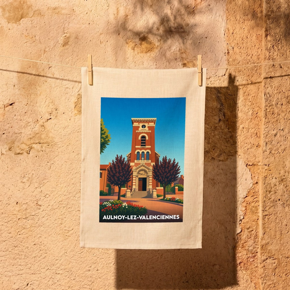 Torchon souvenir de la ville d’Aulnoy-lez-Valenciennes avec une illustration stylisée de son église.