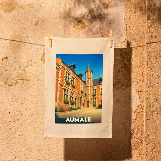 Torchon souvenir de la ville d'Aumale avec une illustration colorée de son architecture historique.