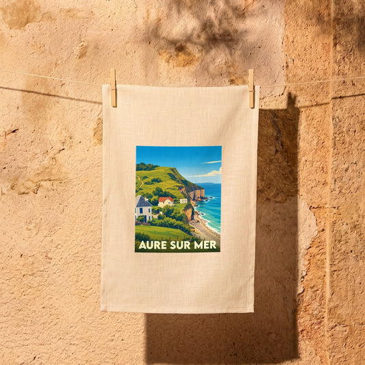 Torchon souvenir de la ville d'Aure-sur-Mer illustré d'un paysage côtier stylisé.