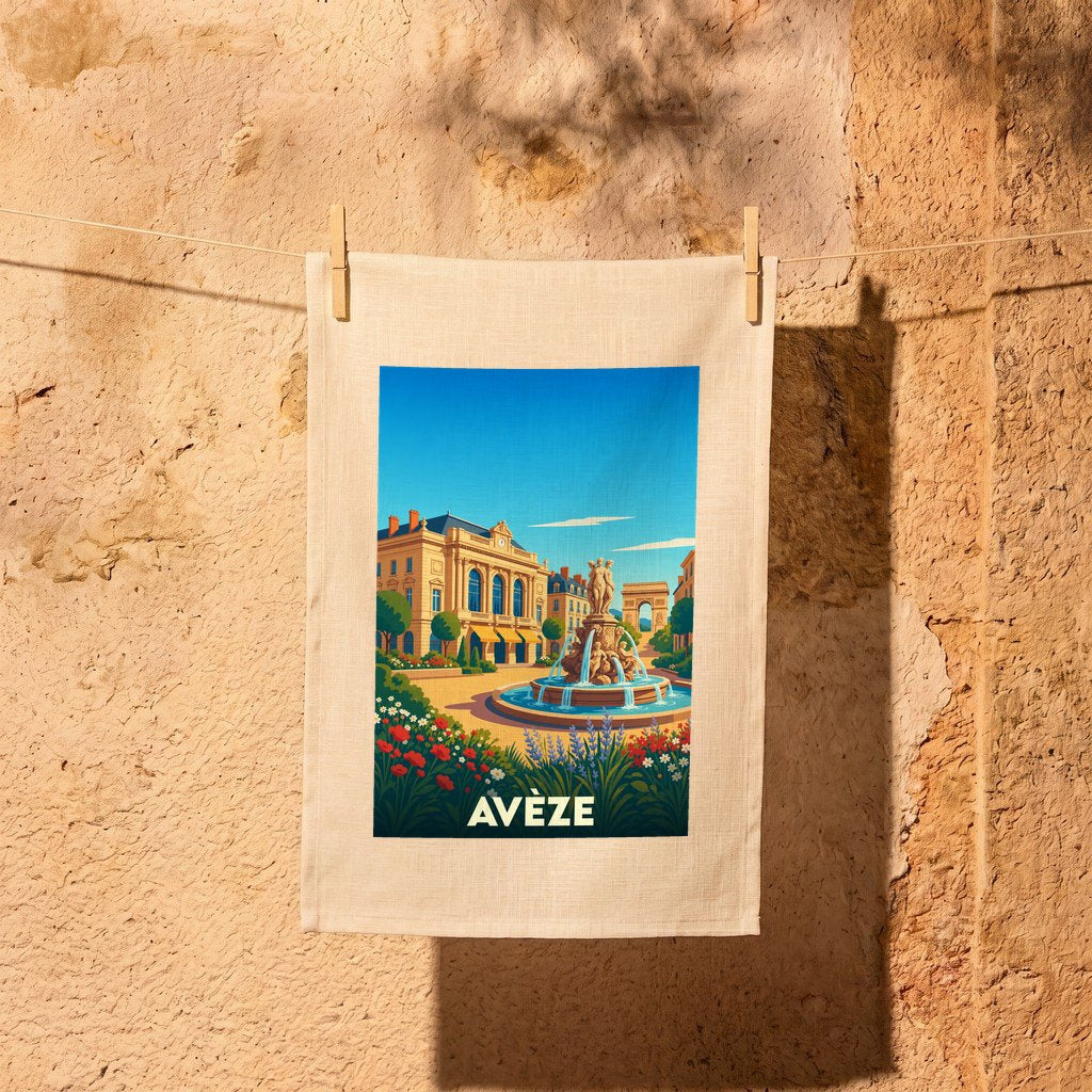 Torchon souvenir de la ville d'Avèze illustré par une scène de place ensoleillée avec fontaine et fleurs.