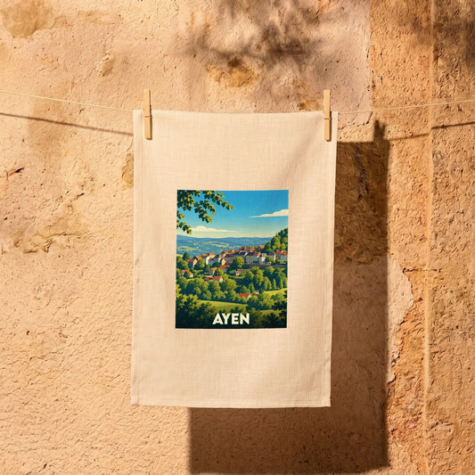 Torchon souvenir de la ville d'Ayen avec une illustration paysagère stylisée.