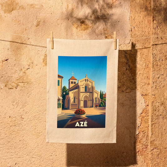 Torchon souvenir de la ville d'Azé orné d'une illustration stylisée de son église sous un ciel bleu.