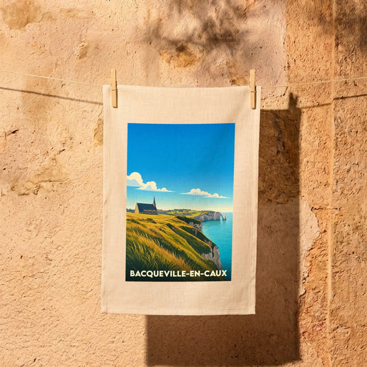 Torchon souvenir de Bacqueville-en-Caux illustré d'un paysage de falaises et d'une église en bord de mer.