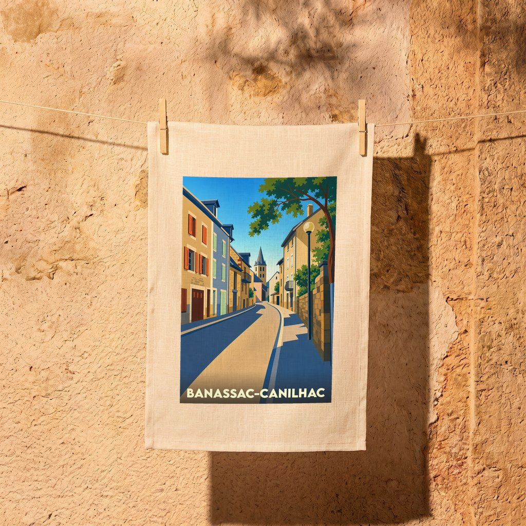 Torchon souvenir de la ville de Banassac-Canilhac avec une illustration stylisée d'une rue typique.