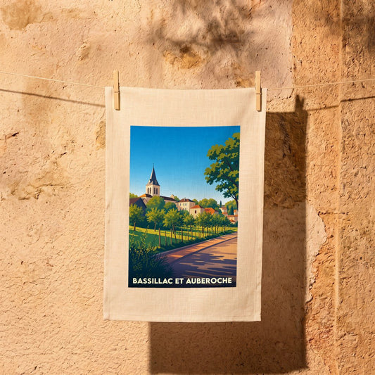 Torchon souvenir de Bassillac et Auberoche illustré d'un paysage de village stylisé.