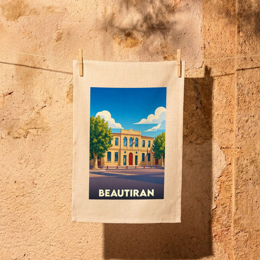 Torchon souvenir de la ville de Beautiran illustré par un dessin stylisé de sa mairie sous un ciel bleu.