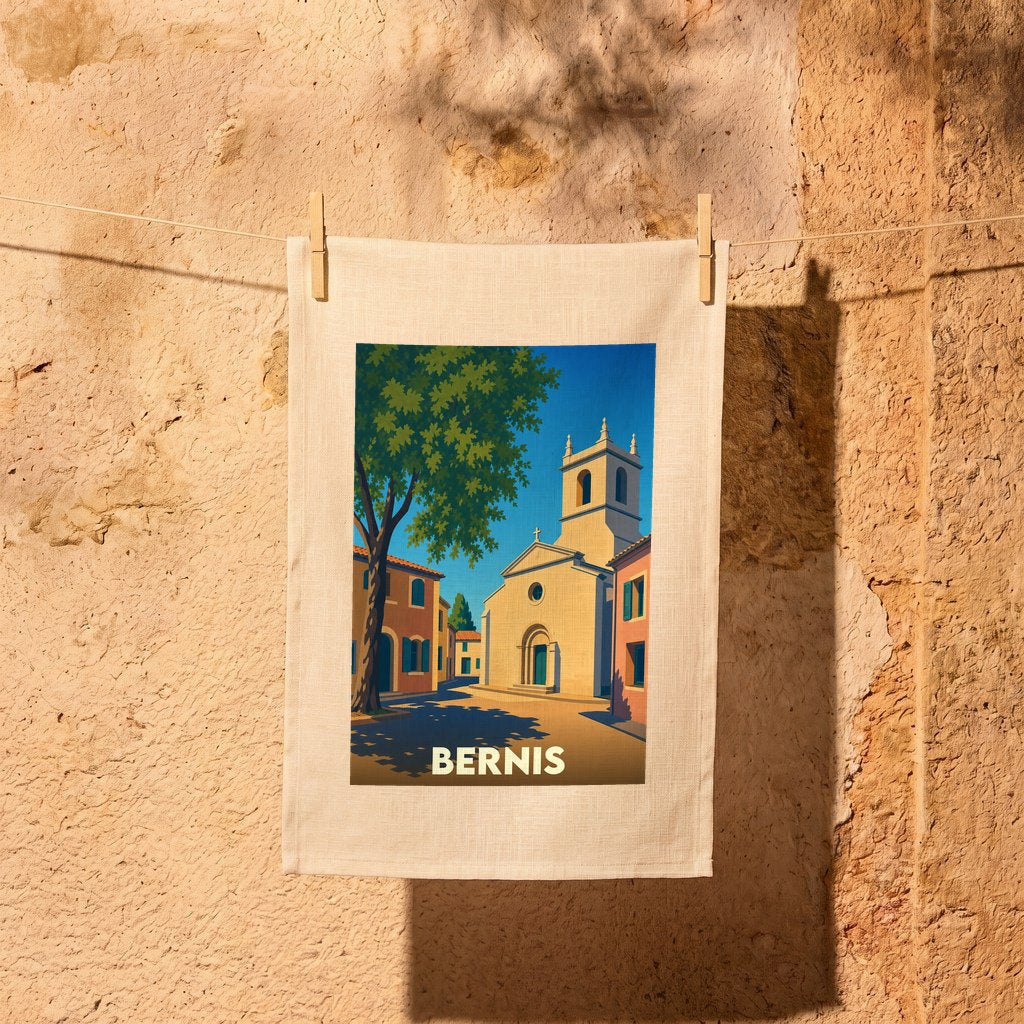Torchon souvenir de la ville de Bernis illustré d'une scène de village ensoleillée.