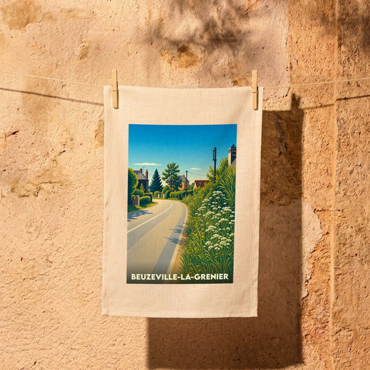 Torchon souvenir de Beuzeville-la-Grenier illustré d'une route de campagne ensoleillée et fleurie.