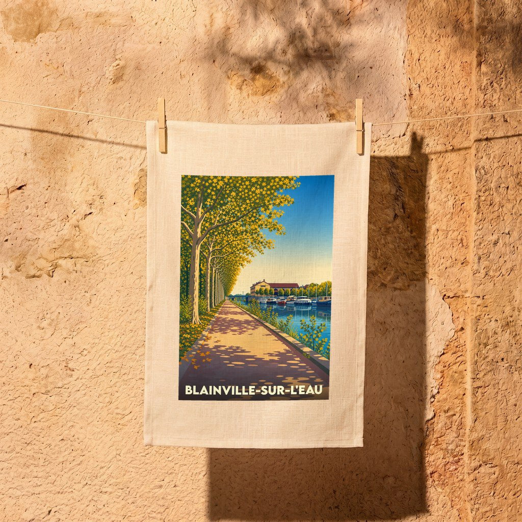 Torchon souvenir de la ville de Blainville-sur-l'Eau avec une illustration stylisée d'un canal bordé d'arbres.