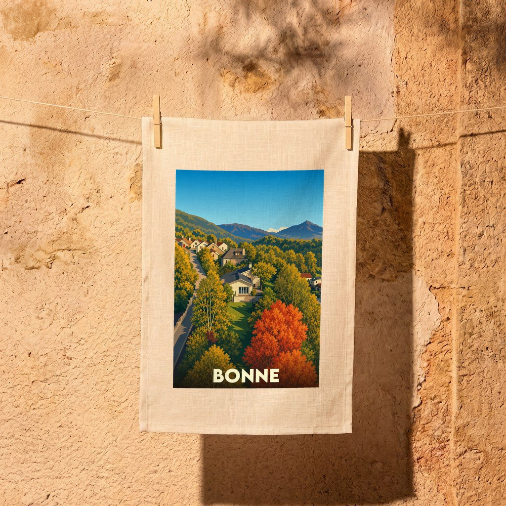 Torchon souvenir de la ville de Bonne avec une illustration stylisée de paysages vallonnés en automne.