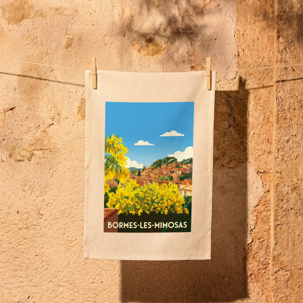 Torchon souvenir de la ville de Bormes-les-Mimosas avec une illustration stylisée.