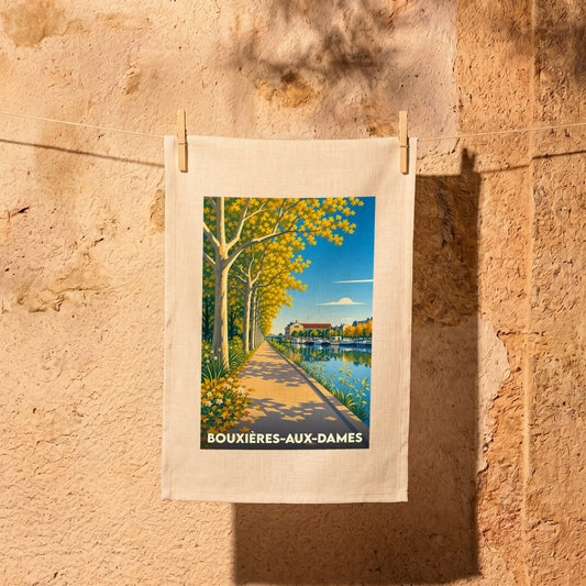 Torchon souvenir de la ville de Bouxières-aux-Dames avec une illustration stylisée d'un quai arboré en automne.