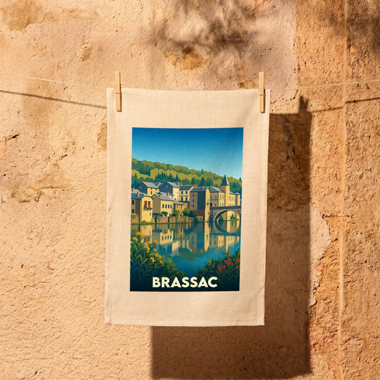 Torchon souvenir de la ville de Brassac orné d'une illustration stylisée de ses maisons au bord de l'eau.