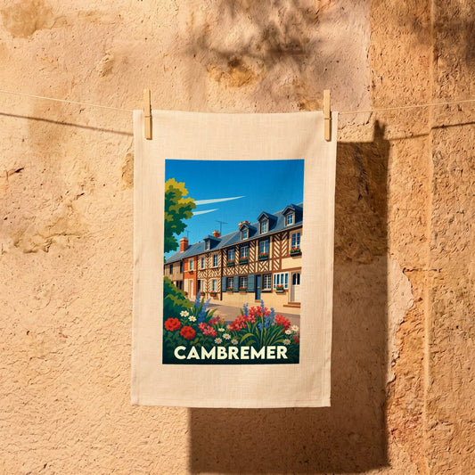 Torchon souvenir de la ville de Cambremer avec une illustration stylisée de maisons normandes fleuries.
