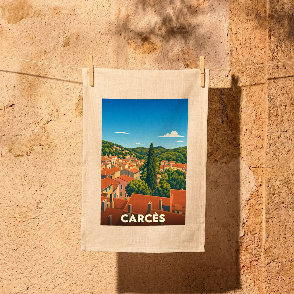 Torchon souvenir de la ville de Carcès illustré d'un paysage provençal stylisé suspendu à un fil à linge.