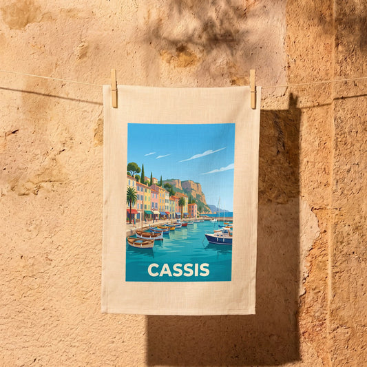 Torchon souvenir de la ville de Cassis avec une illustration stylisée du port et de ses bateaux.
