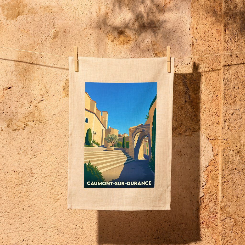 Torchon souvenir de la ville de Caumont-sur-Durance avec une illustration stylisée d'une rue ensoleillée.