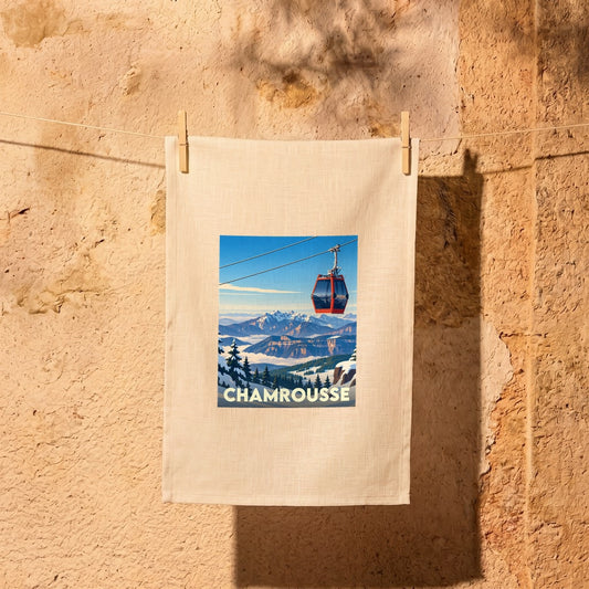 Torchon souvenir de la ville de Chamrousse illustré d'une télécabine survolant les montagnes enneigées.