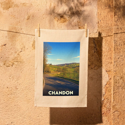 Torchon souvenir de la ville de Chandon avec une illustration paysagère stylisée.