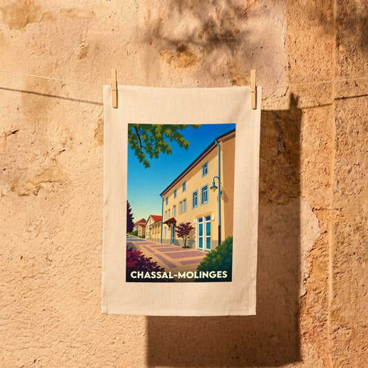 Torchon souvenir de la commune de Chassal-Molinges avec une illustration stylisée de ses bâtiments sous un ciel bleu.
